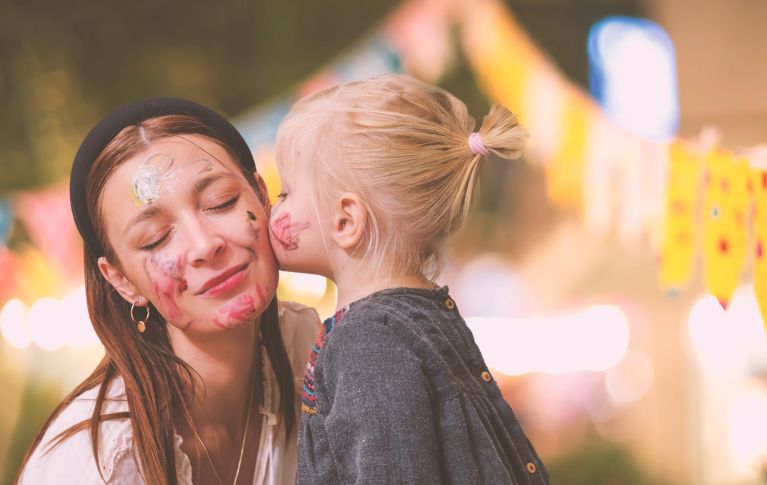 Eine Mutter bekommt einen Kuss von ihrer kleinen Tochter