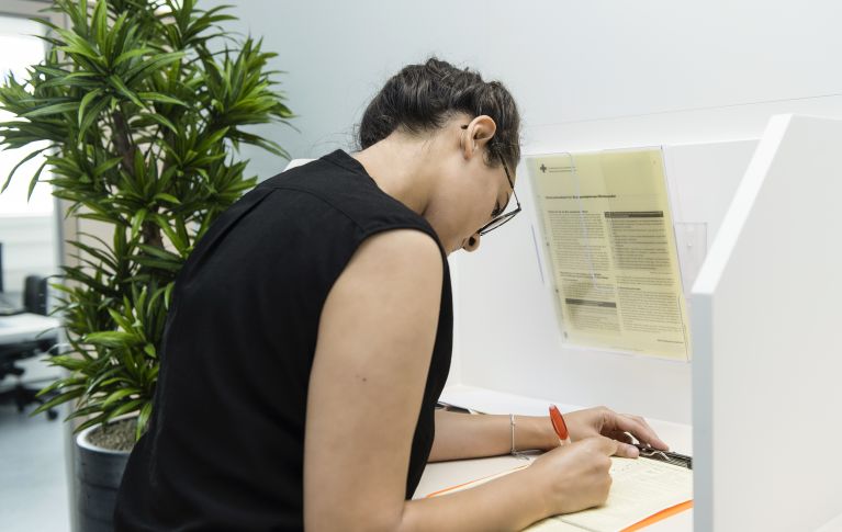 A woman fills out the registration form to donate blood.